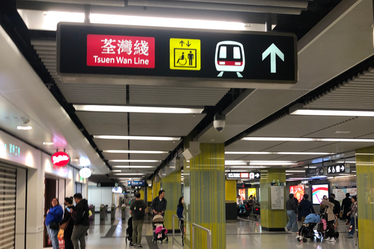 Yellow accessibility sign on the ceiling at a train station