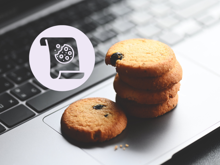 a grey and black laptop keyboard with a stack of cookies with one cookie by itself to the left of the stack.